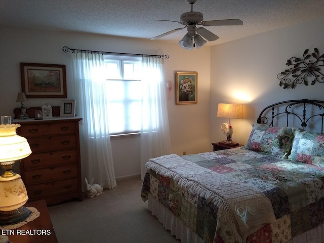 bedroom with light colored carpet, ceiling fan, and a textured ceiling