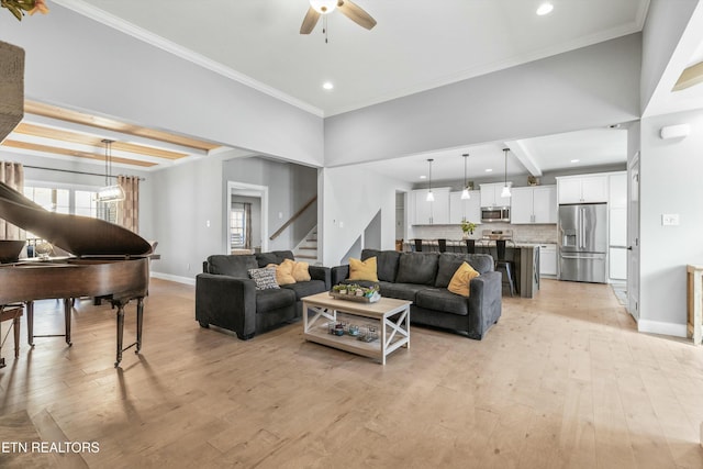 living area featuring light wood-style floors, crown molding, and stairway