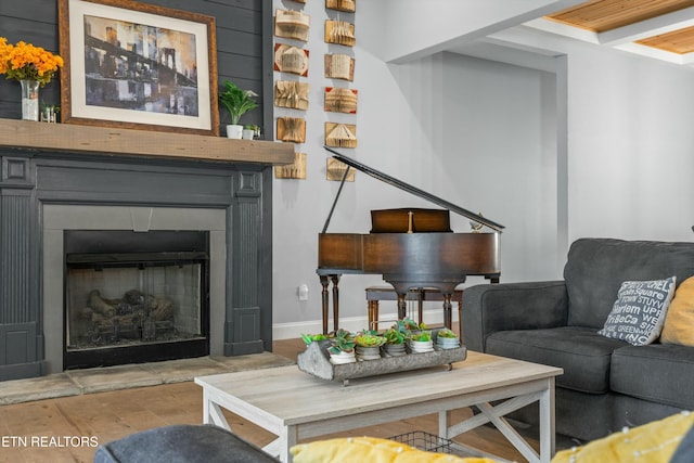 living area featuring a fireplace, wood finished floors, and baseboards