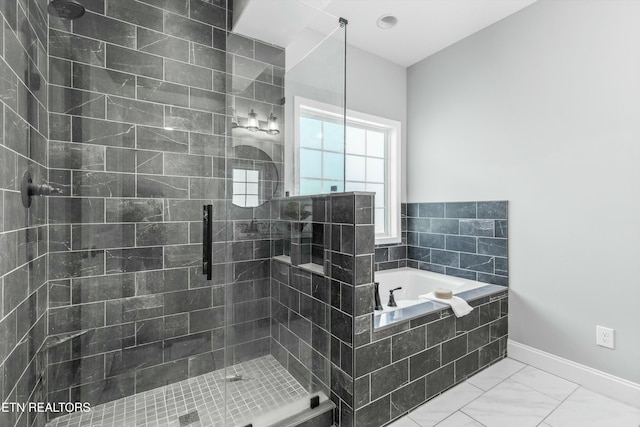 bathroom with a stall shower, marble finish floor, a garden tub, and baseboards