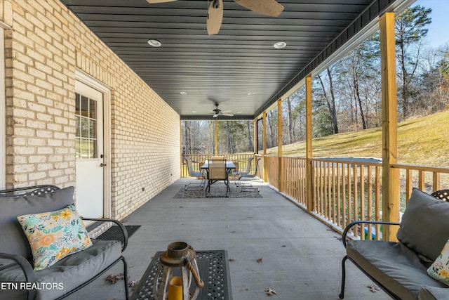 wooden deck featuring outdoor dining area and a ceiling fan