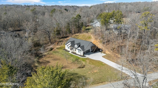 drone / aerial view featuring a wooded view