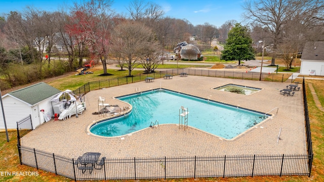 community pool featuring a yard, a patio, and fence