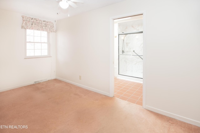 unfurnished room with visible vents, light carpet, baseboards, and ceiling fan