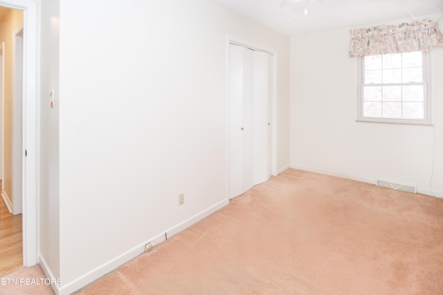 unfurnished room featuring ceiling fan, baseboards, visible vents, and light carpet