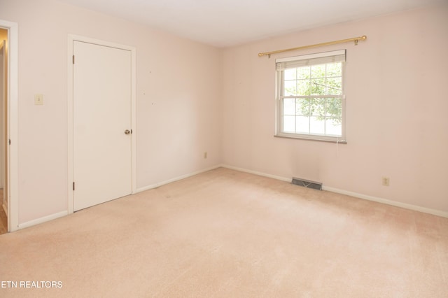 unfurnished room with carpet flooring, baseboards, and visible vents