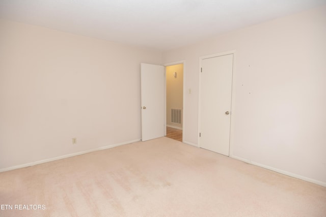 spare room with visible vents, baseboards, and carpet flooring