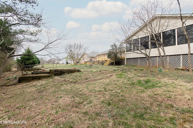 view of yard featuring a garden and a sunroom