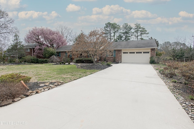 single story home with brick siding, concrete driveway, a front yard, and a garage