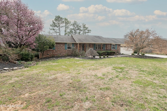 ranch-style home with crawl space, a garage, brick siding, and a front lawn