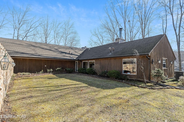 back of property featuring a chimney, cooling unit, and a yard