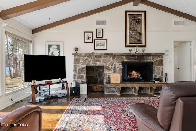 living area with lofted ceiling with beams, a fireplace, and visible vents