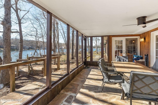 sunroom / solarium with a water view and a ceiling fan