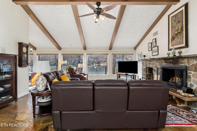 living room with vaulted ceiling with beams, visible vents, a ceiling fan, and a stone fireplace