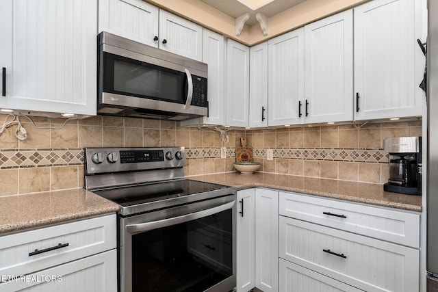 kitchen with white cabinetry, appliances with stainless steel finishes, decorative backsplash, and light stone counters