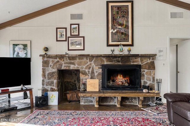 living area with vaulted ceiling, visible vents, a fireplace, and wood finished floors