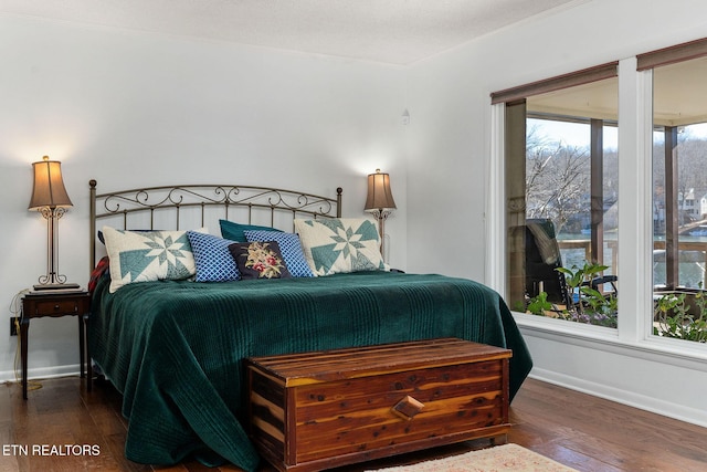 bedroom with dark wood-style floors, baseboards, and crown molding