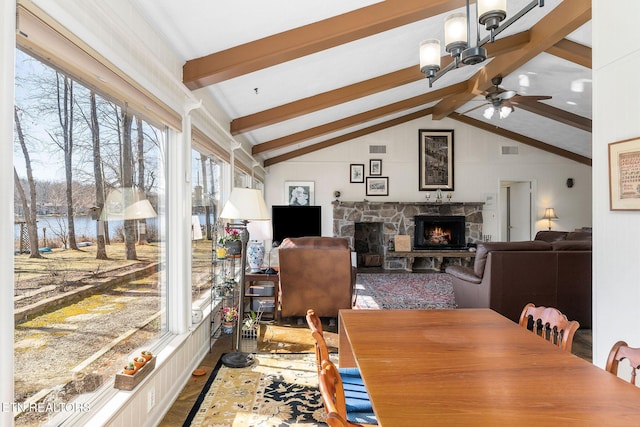 dining space featuring vaulted ceiling with beams, a fireplace, and visible vents