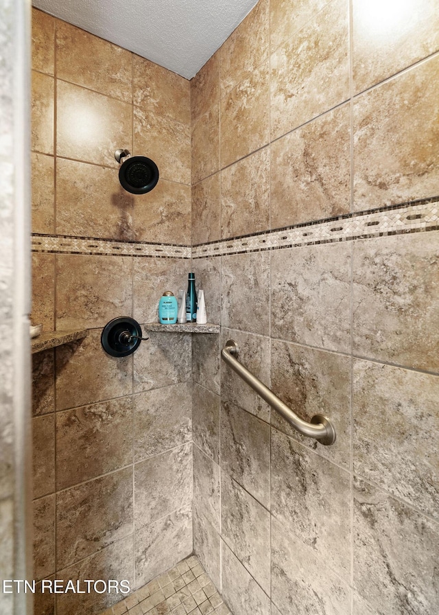 room details featuring a textured ceiling and tiled shower