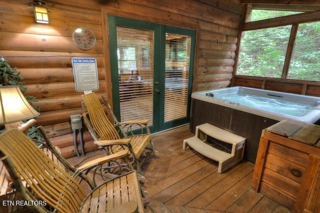 sunroom with a hot tub and french doors