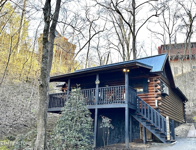 exterior space featuring stairs, log siding, and metal roof