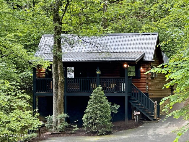 831 Bear Run Way, Sevierville, TN 37862 - view of front facade with log exterior, metal roof, a forest view, and stairs
