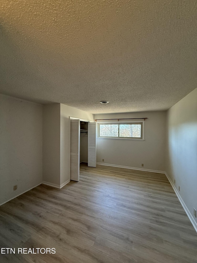 7000 Big Horn Dr Unit A-3, Crossville, TN 38572 - unfurnished bedroom with a textured ceiling, a closet, wood finished floors, and baseboards