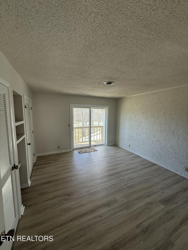7000 Big Horn Dr Unit A-3, Crossville, TN 38572 - spare room featuring a textured ceiling, a textured wall, dark wood-type flooring, and visible vents