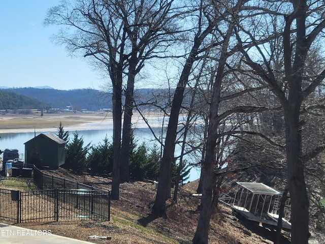 exterior space with a water view and fence