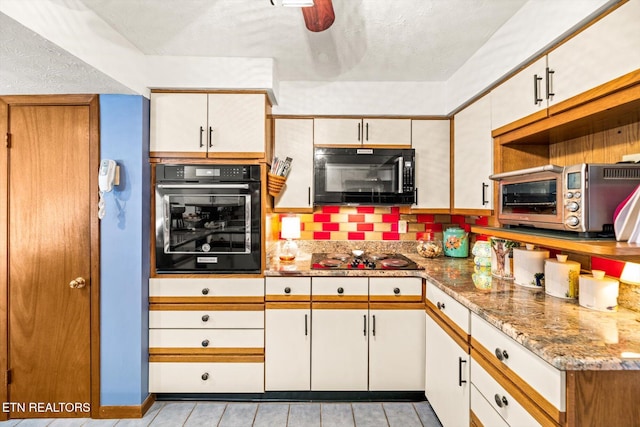 kitchen with black appliances, light stone countertops, a toaster, a textured ceiling, and a ceiling fan