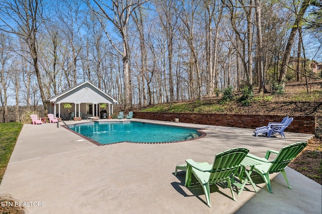 pool with a gazebo, a diving board, and a patio