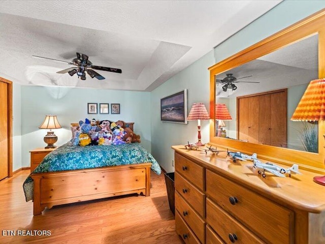 bedroom featuring a textured ceiling, light wood-type flooring, and ceiling fan