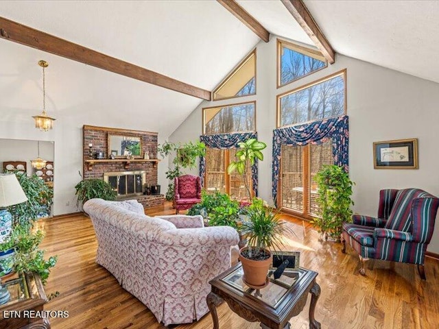 living room with beam ceiling, a fireplace, high vaulted ceiling, and wood finished floors