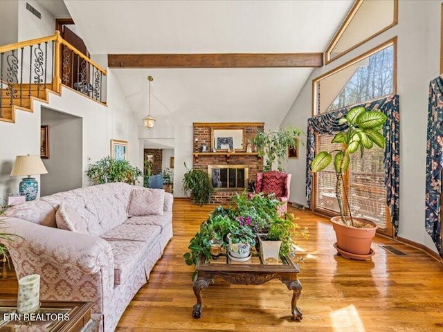 living area featuring visible vents, high vaulted ceiling, beamed ceiling, and wood finished floors