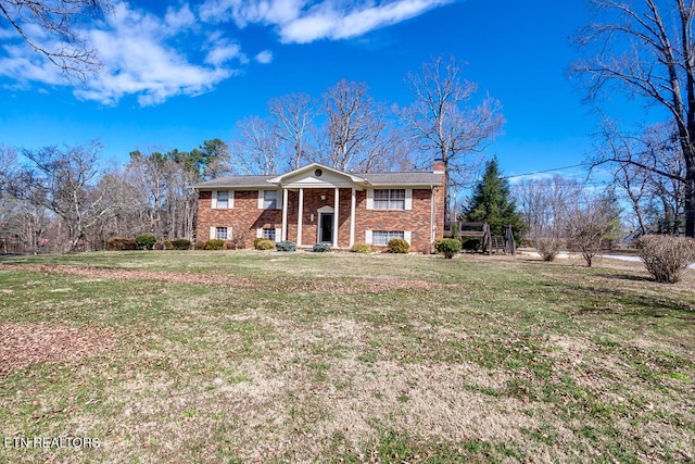 view of front of home featuring brick siding, a chimney, and a front lawn