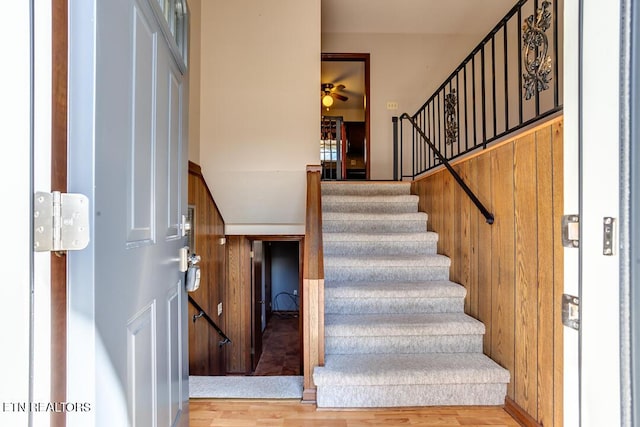 staircase featuring ceiling fan and wood finished floors