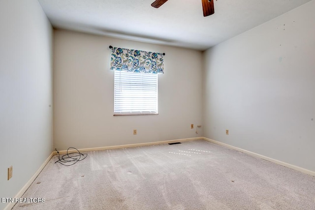 empty room with carpet floors, visible vents, baseboards, and a ceiling fan