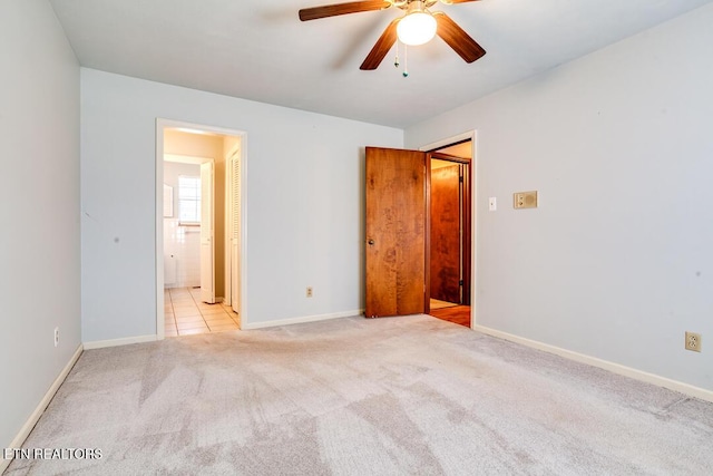 interior space with light carpet, ceiling fan, and baseboards