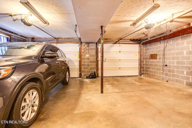 garage with concrete block wall and a garage door opener