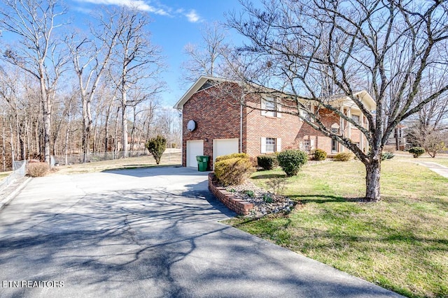 view of home's exterior with a garage, a yard, brick siding, and driveway