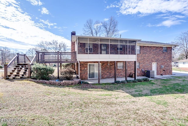 back of property with a sunroom, a chimney, a wooden deck, central air condition unit, and a patio area