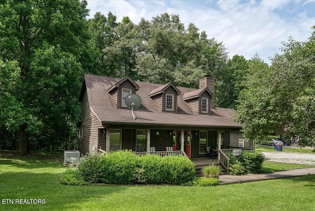 cape cod house with central AC unit, a porch, roof with shingles, a chimney, and a front yard