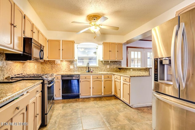 kitchen with light stone counters, a sink, a ceiling fan, decorative backsplash, and black appliances