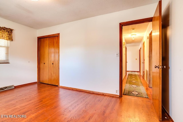 empty room with visible vents, baseboards, and wood finished floors