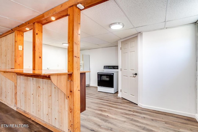 kitchen with white range with electric cooktop, wood finished floors, a paneled ceiling, and baseboards