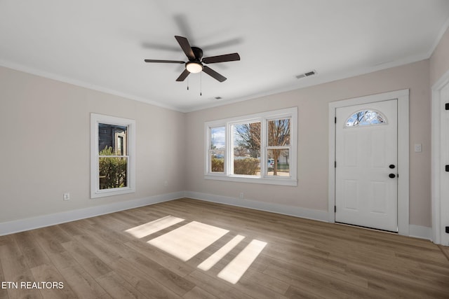 foyer entrance with baseboards, visible vents, ceiling fan, crown molding, and light wood-type flooring