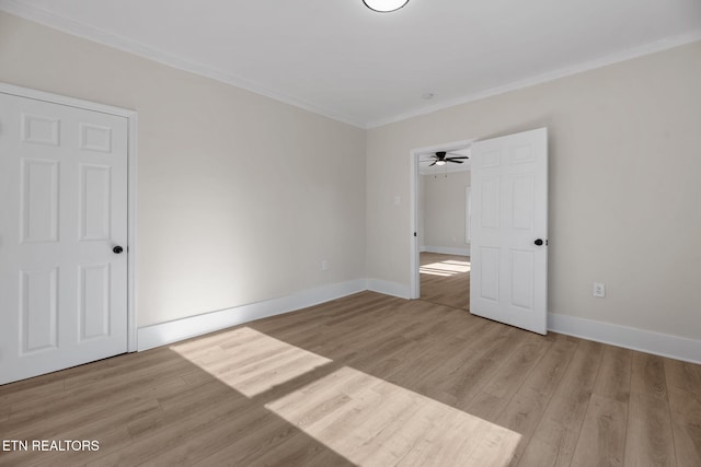 unfurnished bedroom featuring light wood-type flooring, baseboards, and crown molding