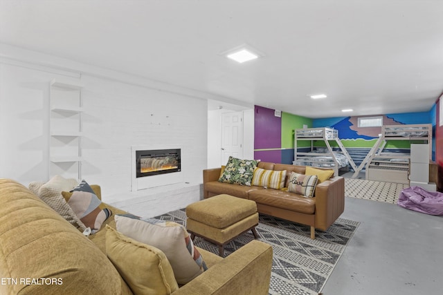 living area featuring finished concrete flooring and a glass covered fireplace