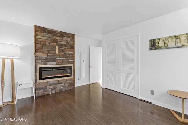 unfurnished living room featuring a fireplace, baseboards, and wood finished floors