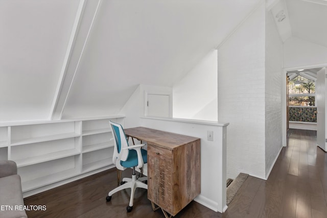 office area with lofted ceiling, brick wall, and wood finished floors